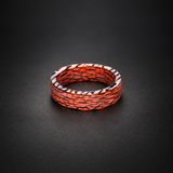 Fire Ghost Matrix red, black, and pale carbon fiber ring resting flat in a dark studio setting