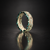 Fire Ghost Matrix carbon fiber ring with pale white and teal illuminated strands, shown upright with a soft reflection
