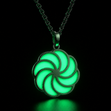 Sterling silver luminous spiral pendant glowing green in dark lighting