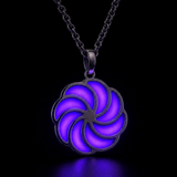 Sterling silver luminous spiral pendant glowing indigo in dark lighting