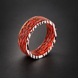 Fire Ghost Matrix carbon fiber ring with red, black, and pale layered strands, shown upright in a dark studio setting