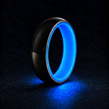 Luminescent Luxe sterling silver 5 mm ring with Cobalt Blue liner, glowing powerfully in deep darkness, on a subtly cooler gray background.