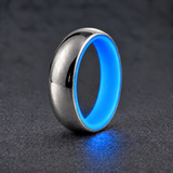 Luminescent Luxe sterling silver 5 mm ring with Cobalt Blue liner, glowing softly in dim light, on a subtly cooler gray background.