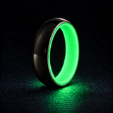 Luminescent Luxe sterling silver 5 mm ring with Ultimate Green liner, glowing powerfully in deep darkness, on a subtly cooler gray background.