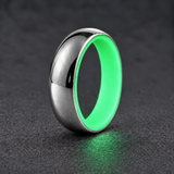 Luminescent Luxe sterling silver 5 mm ring with Ultimate Green liner, glowing softly in dim light, on a subtly cooler gray background.