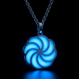 Sterling silver luminous spiral pendant glowing light blue in dark lighting