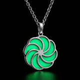 Sterling silver luminous spiral pendant in green with a subtle teal tint, shown in daylight