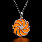 Sterling silver luminous spiral pendant in orange, shown in daylight