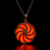 Sterling silver luminous spiral pendant glowing orange-red in dark lighting