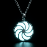 Sterling silver luminous spiral pendant glowing white with a teal tint in dark lighting