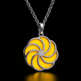 Sterling silver luminous spiral pendant in yellow, shown in daylight