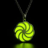 Sterling silver luminous spiral pendant glowing lime green in dark lighting